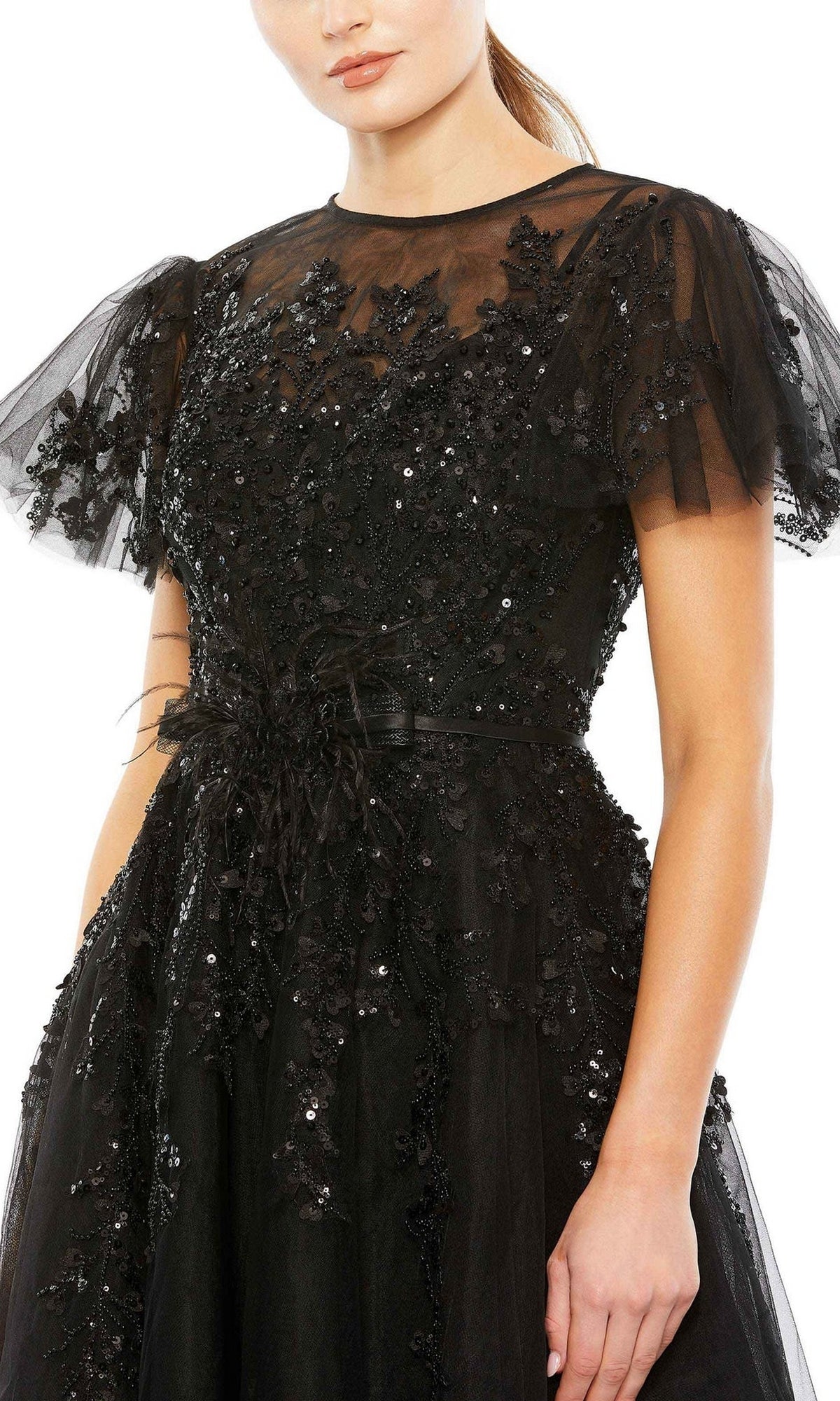 A woman wears the Long Formal Dress 20362 by Mac Duggal, featuring a black A-line silhouette with floral lace, bead detailing, sheer yoke, and short sleeves for an elegant look.